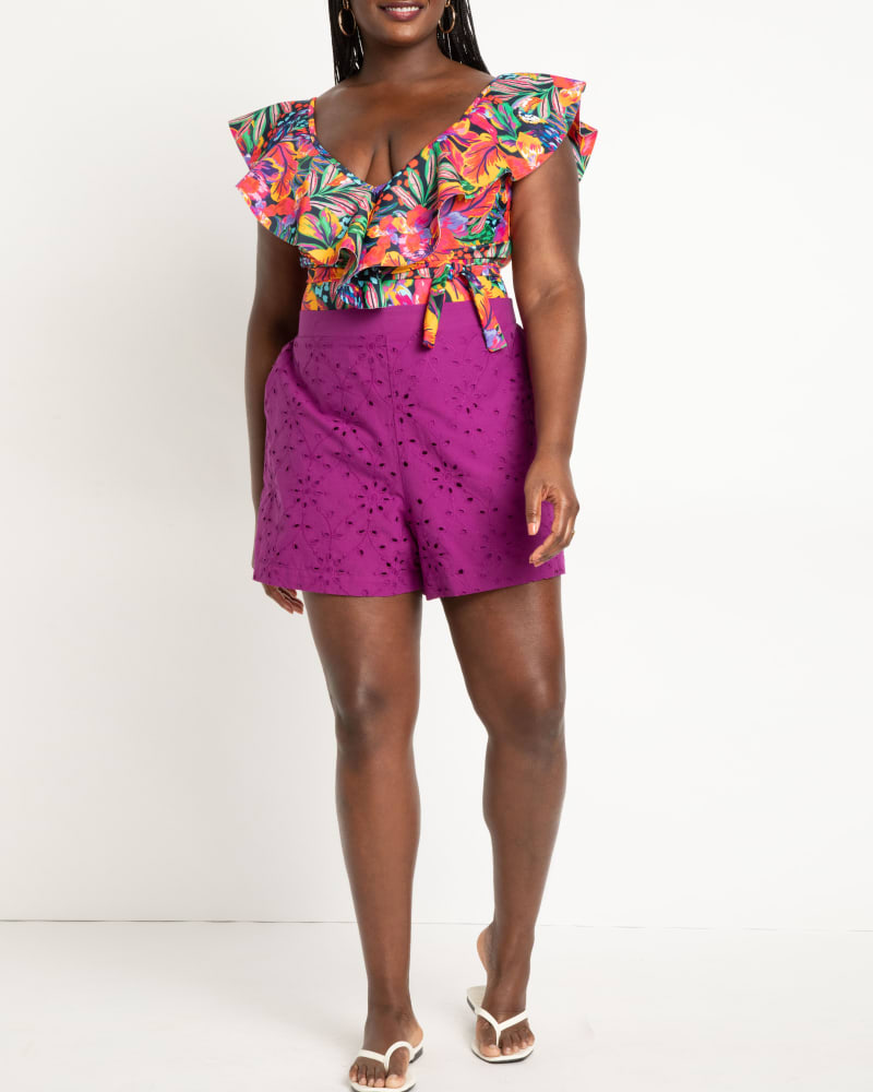 Front of a model wearing a size 18 Eyelet Coverup Shorts in Prism Violet by ELOQUII. | dia_product_style_image_id:272794